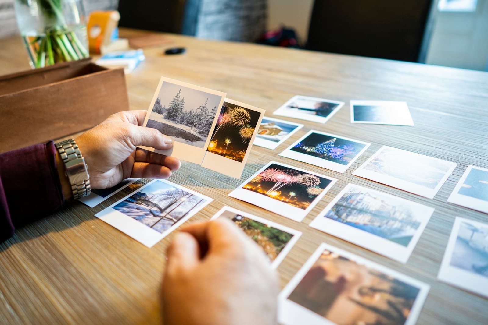 Printed photographs spread on a wooden table